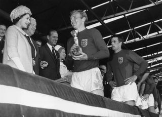Queen Elizabeth II smiles after presenting England captain Bobby Moore with the trophy