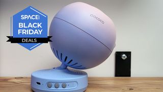 A Pococo Galaxy Star Projector on a wooden table.