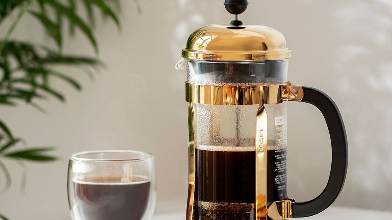 A brass colored Bodum French Press coffee maker