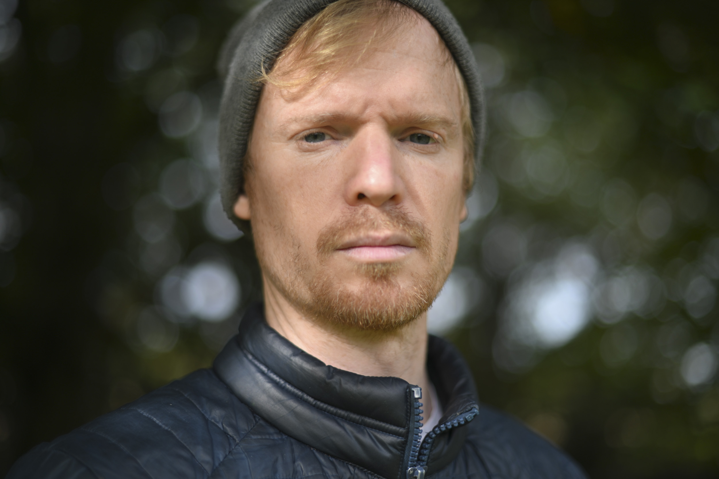 Head and shoulder portrait, outdoors, shallow depth of field, dappled light through tree leaves