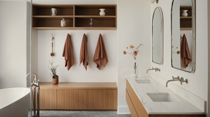 A neutral bathroom with wooden storage bench