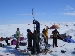 Sun on the Greenland Ice Sheet melts the ice surface, but a new study shows what happens next isn’t the same across the ice sheet. In this photo, researchers align a borehole in Greenland.