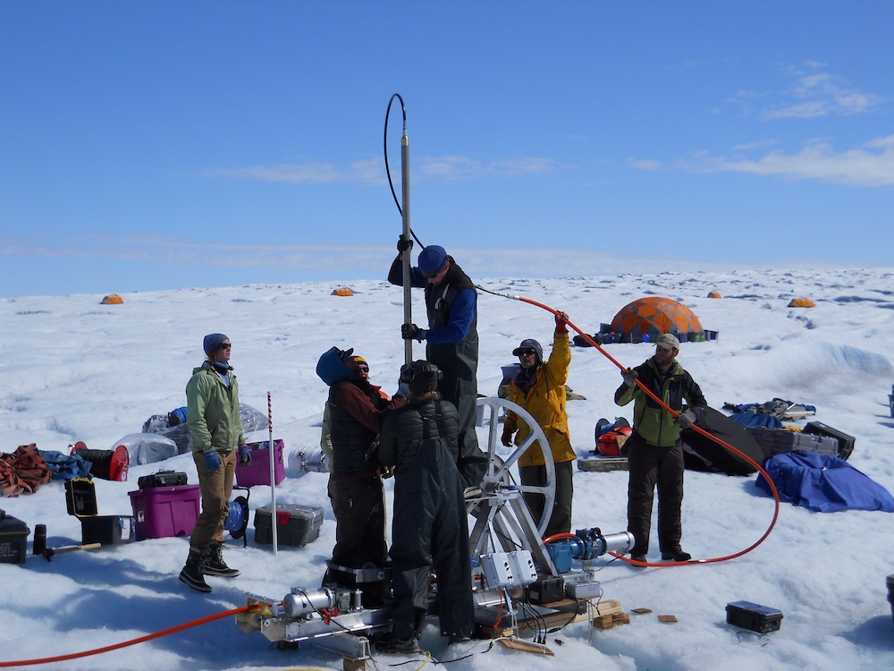 Sun on the Greenland Ice Sheet melts the ice surface, but a new study shows what happens next isn’t the same across the ice sheet. In this photo, researchers align a borehole in Greenland.