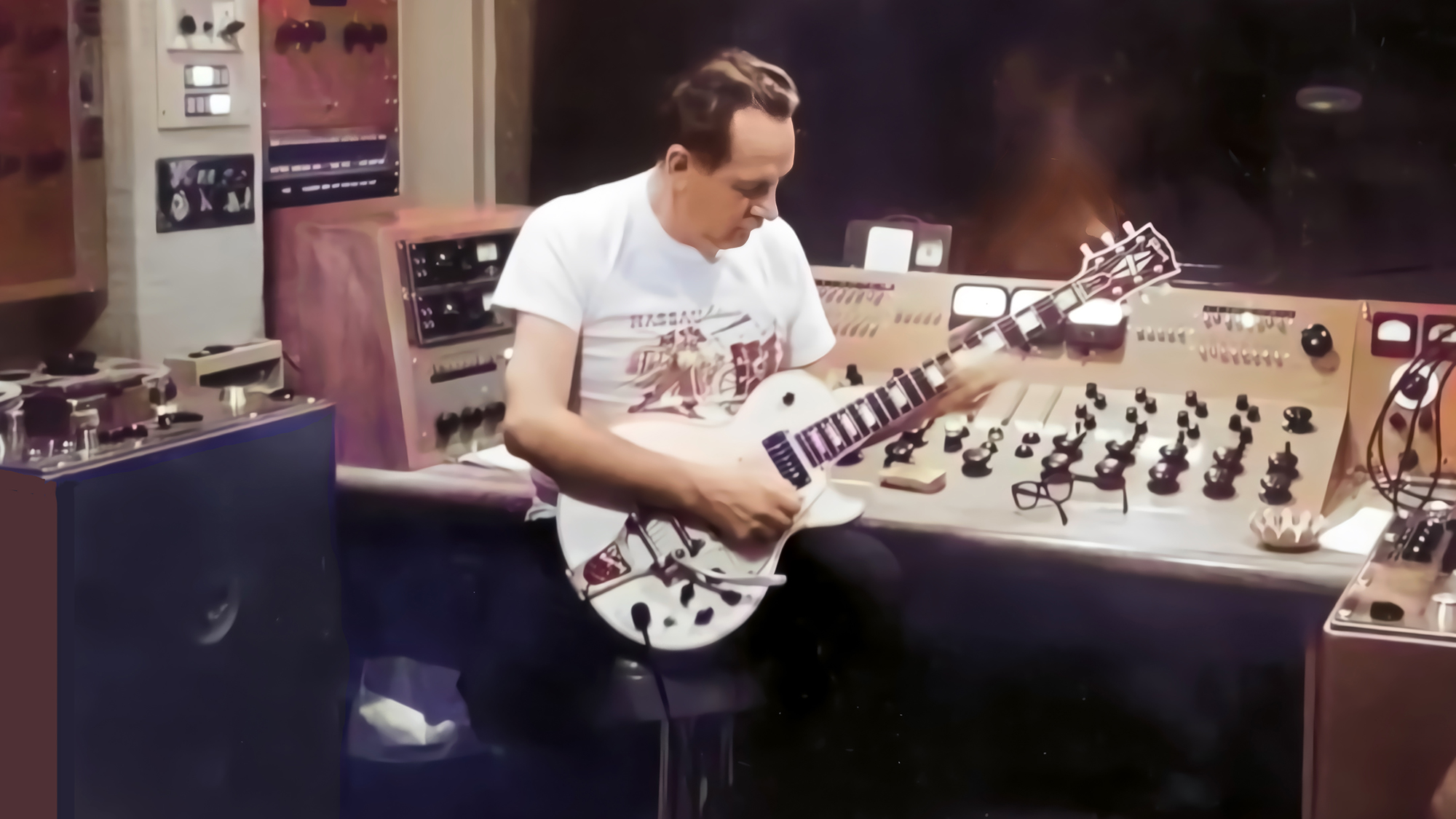 Les Paul plays a modified Gibson Les Paul with a Bigsby vibrato as he sits at the Monster, the eight-channel console he designed in the 1950s with Rein Narma, which featured cutting-edge in-line equalization and vibrato effects