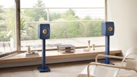 KEF LS50 Meta in royal blue on stands in a living room setting
