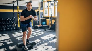 Man doing poliquin step-up in a gym