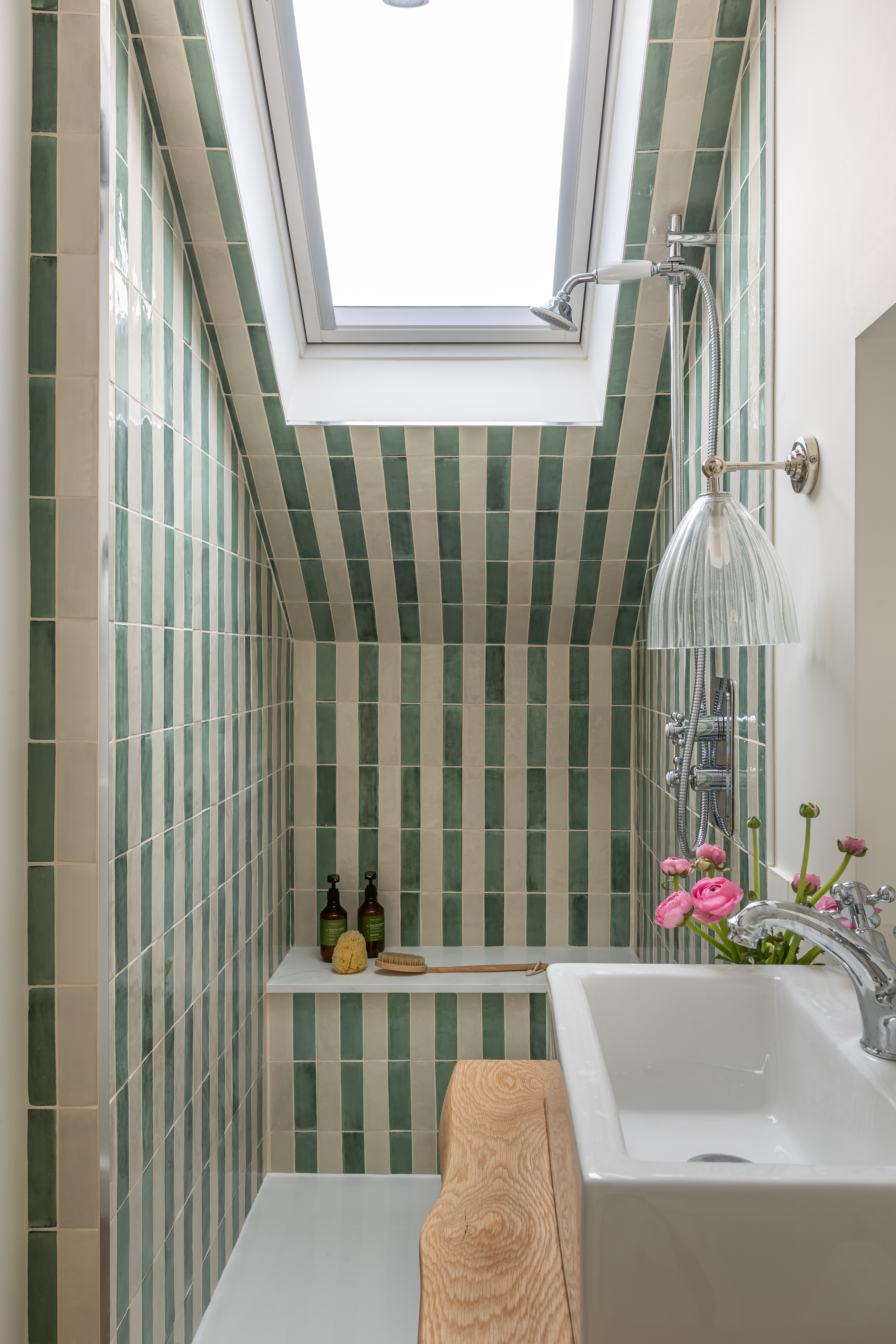 loft conversion en suite with a green and white tiled bathroom with a seat