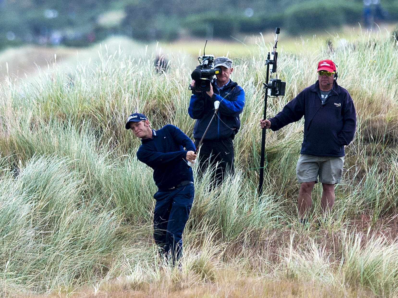 The cameramen stand behind JB Hansen as he plays from deep undergrowth