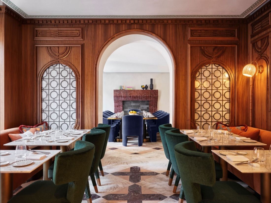 A quirkily conceived hotel restaurant blends past and present with wood-drenched Art Deco style architectural elements and mid-century modern plush furniture.