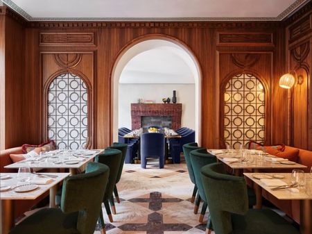 A quirkily conceived hotel restaurant blends past and present with wood-drenched Art Deco style architectural elements and mid-century modern plush furniture.