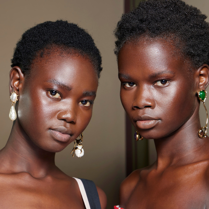 two black woman with large earrings and glowing skin