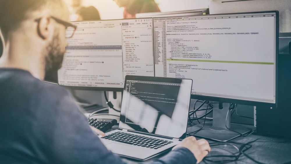 Man writing code on a laptop