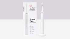 Spotlight Oral Care Sonic toothbrush in white, with packaging and on USB charging platform