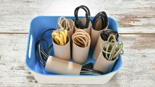 A collection of wires tidied using the cardboard tubes of toilet rolls