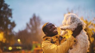 Man smiling holding dog