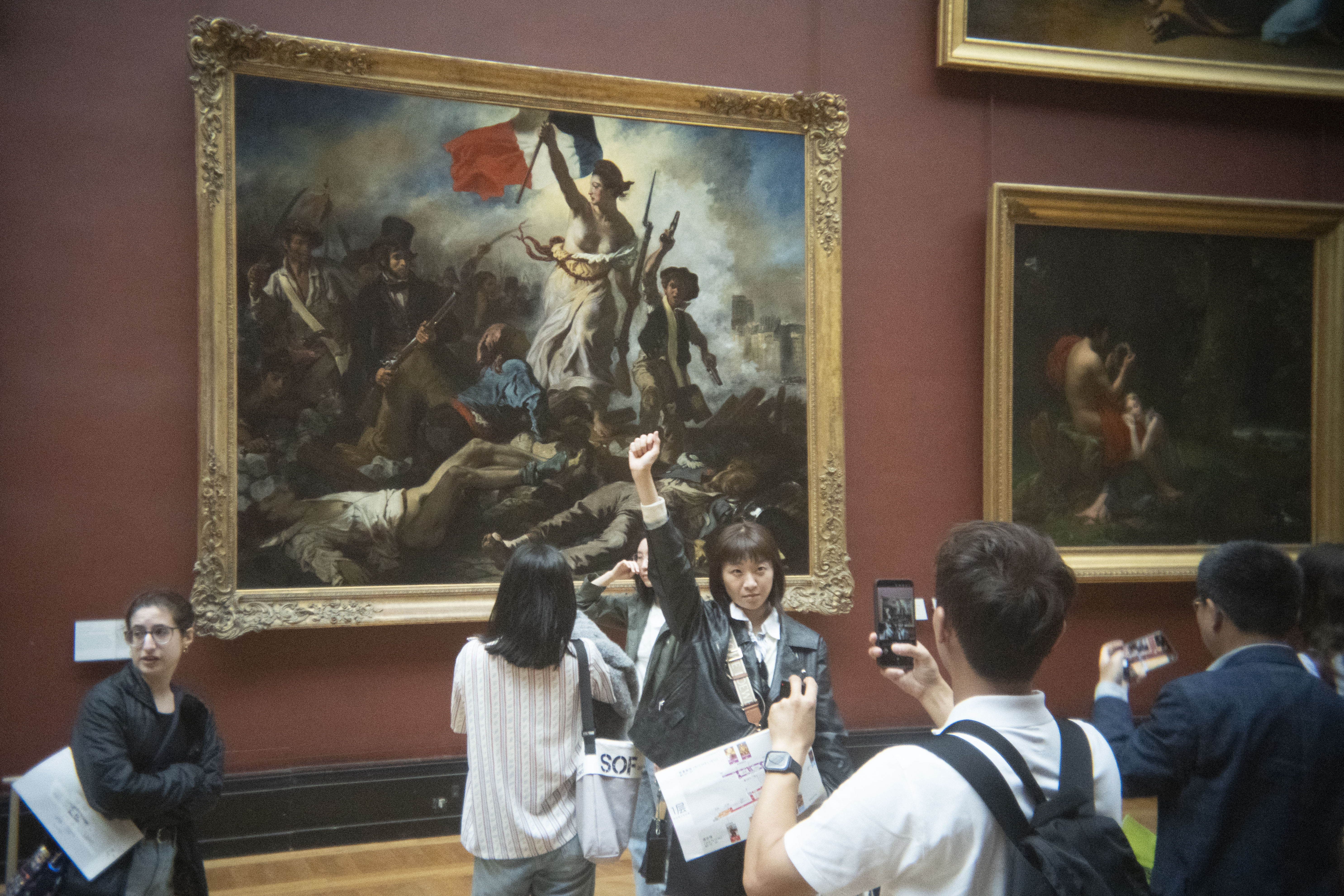A shot of people in The Louvre reacting to paintings