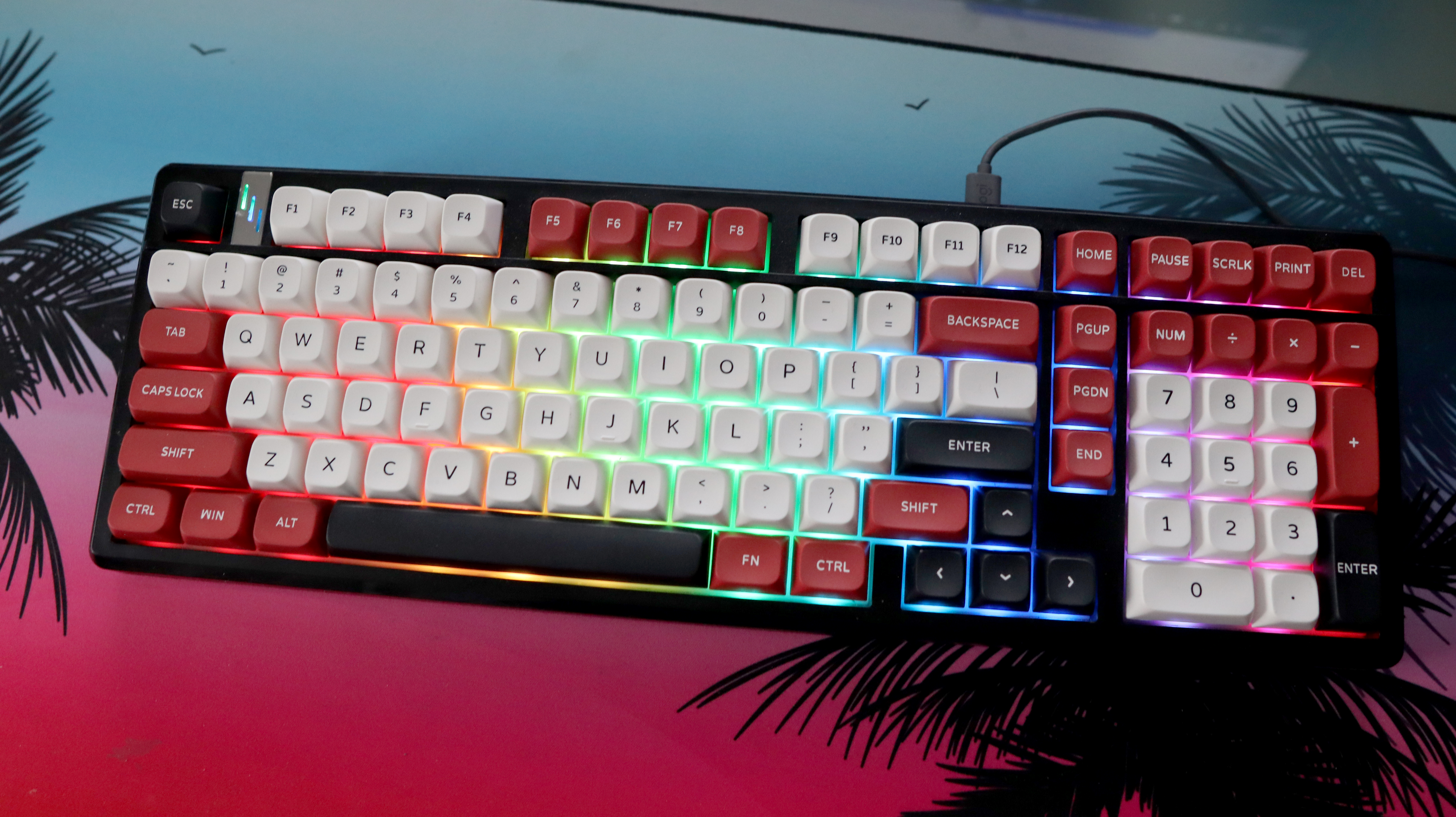 The Gamakay TK101 gaming keyboard in a red and white colourway and on a colourful mouse pad.