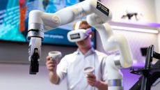 A person operating a 5G-powered robotic arm with the help of remote controls and a VR headset