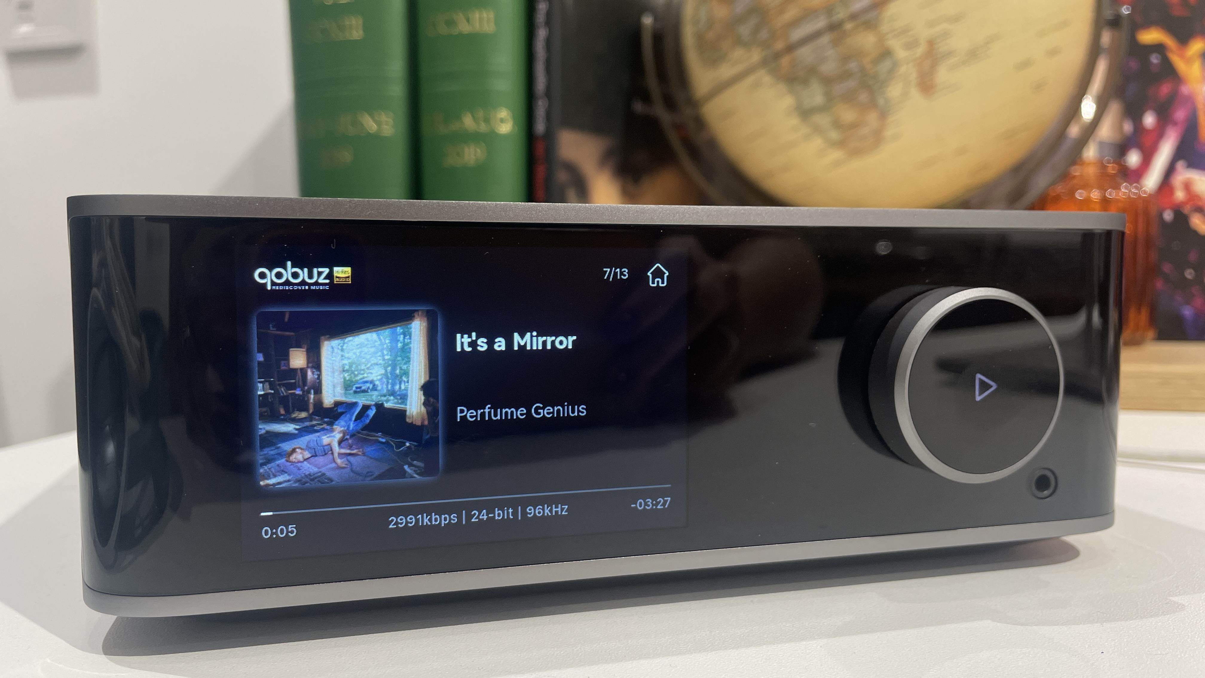 WiiM Ultra with display screen showing album artwork and bitrate