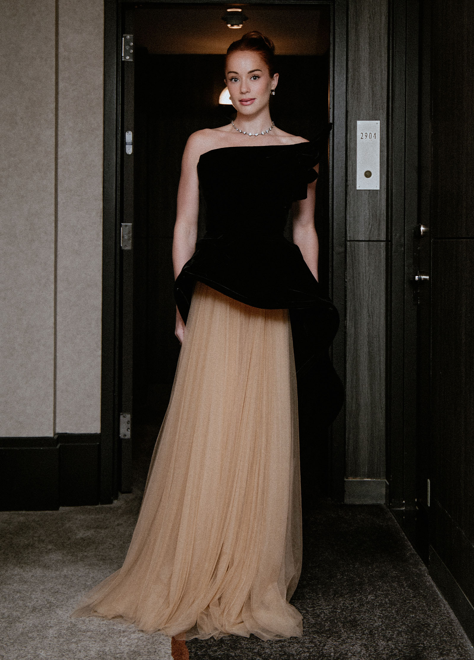 Whitney Leavitt wears a Marchesa gown featuring a sculptural black bodice and blush tulle skirt and Fred Leighton jewelry.