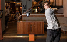 A golfer hits a drive indoors at Pitch Golf