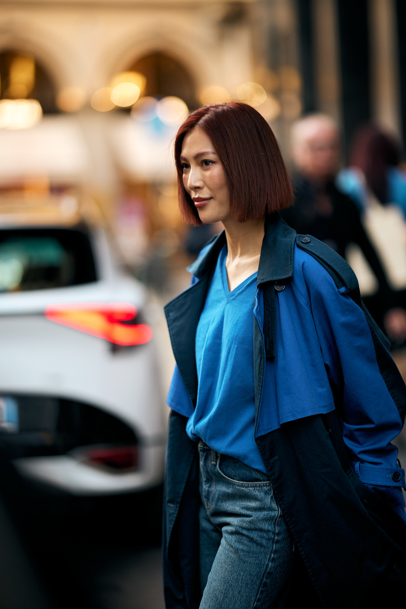 an asian woman with a blunt red bob and blue sweater