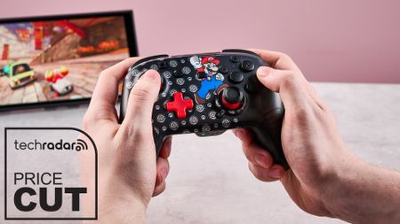 Man holding Turtle Beach Rematch Wireless Controller for Nintendo Switch 2, playing Mario Kart World, with badge that reads 'TechRadar: price cut'