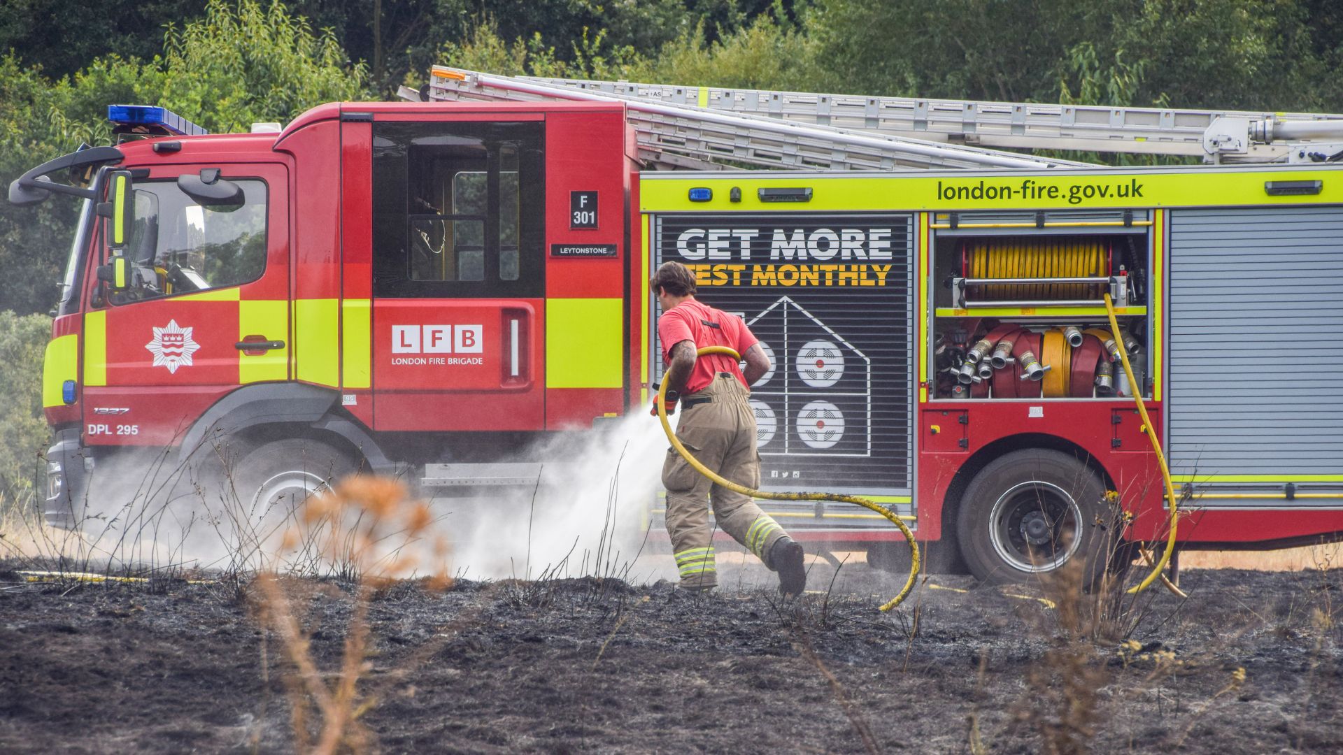  A London Fire Brigade firefighter extinguishes a grass fire in a field
