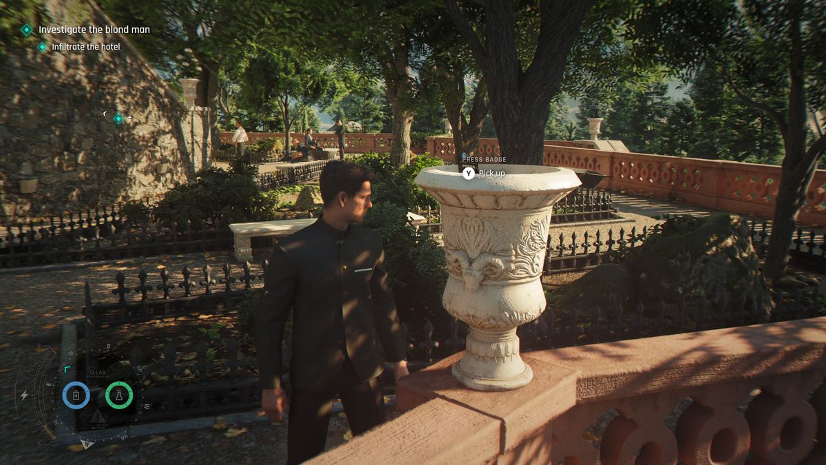 007 First Light - James stands beside a large flower pot with a press badge inside