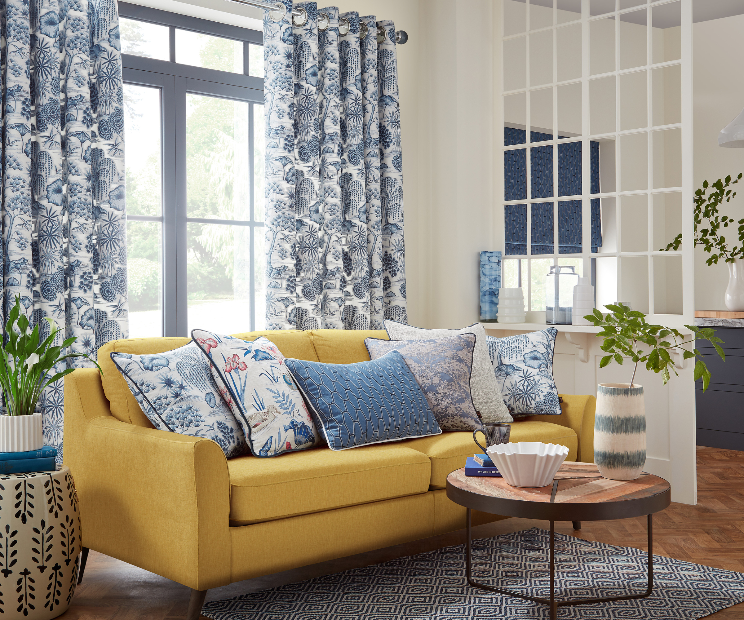 yellow sofas in open plan living space with blue and white curtains