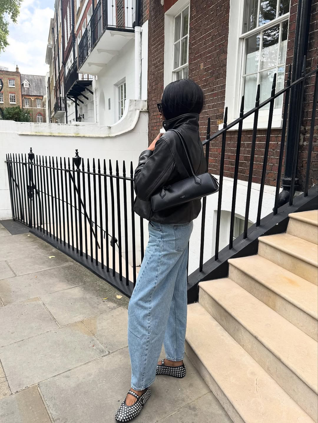 Woman wearing collared leather jacket trend fall 2025.