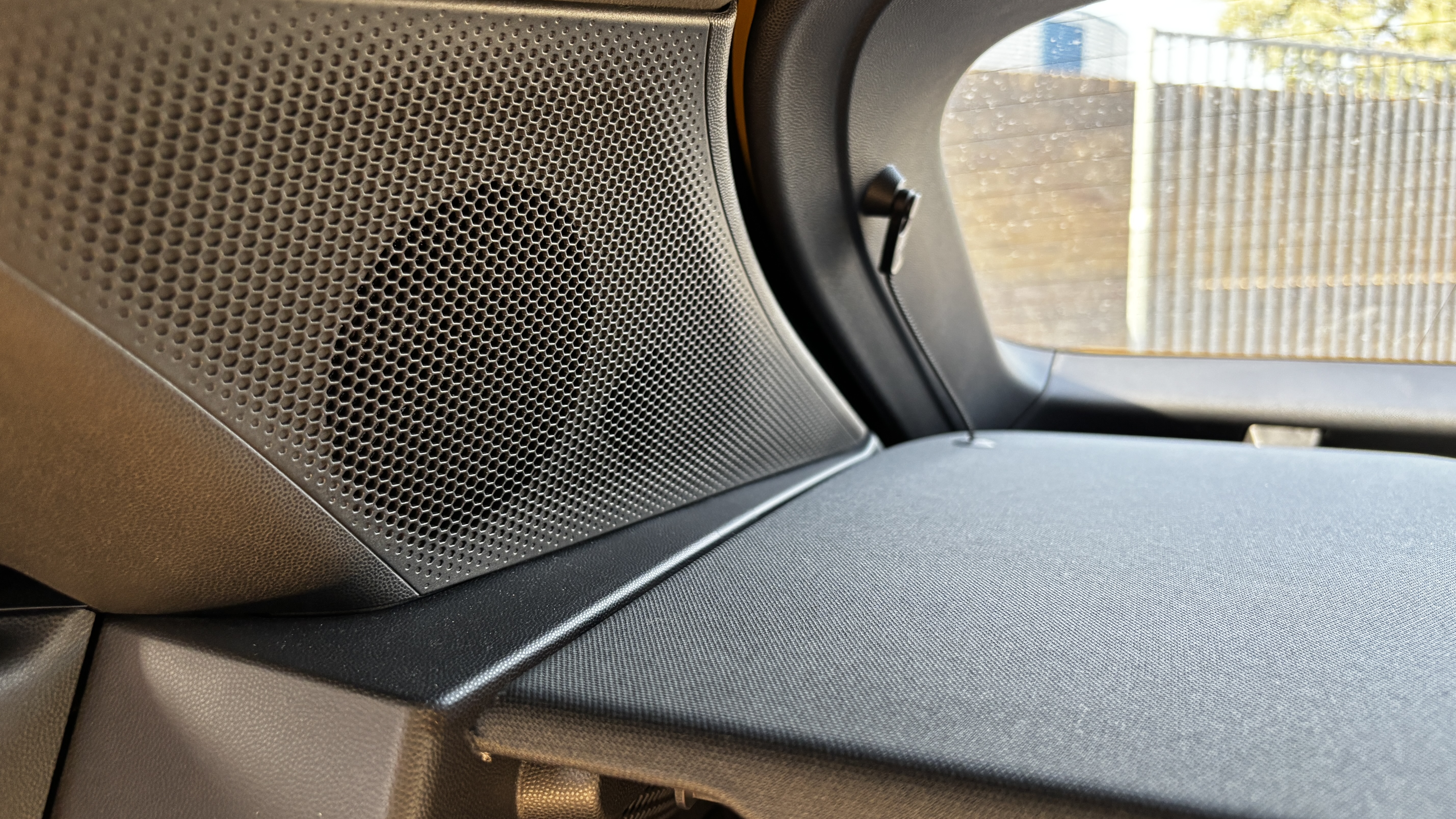 Speaker grille covering the mid-range speaker and tweeter in the back of a Porsche Macan Electric