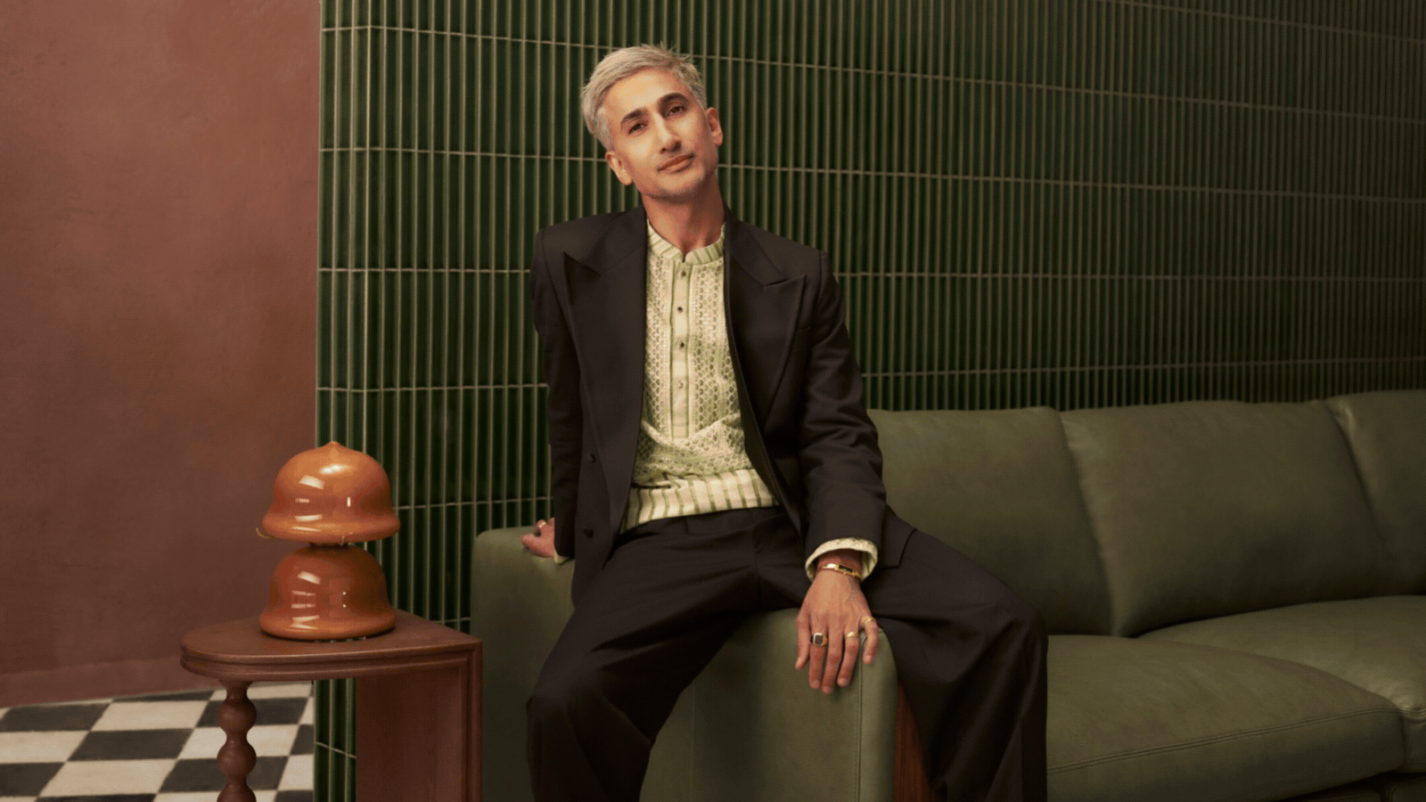 a gif of tan france's furniture collaboration with castlery including a green sofa, orange armchair, lamps, a coffee table, and cushions