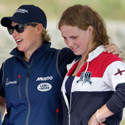 Zara Tindall wearing a blue jacket putting her arm around Stephanie Phillips