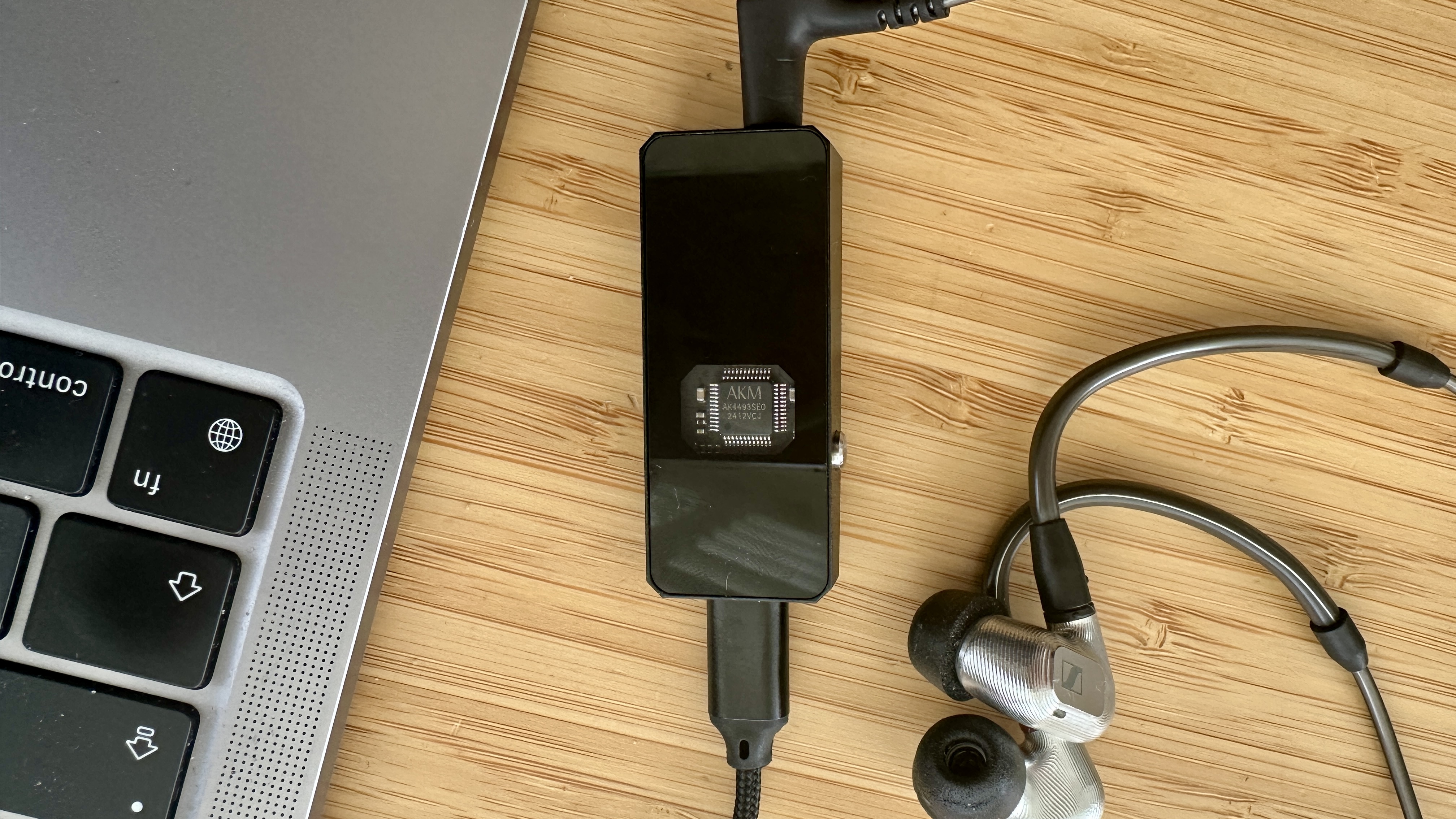 Rear panel of the Campfire Audio Relay headphone amp/DAC (showing the AKM DAC chip) on a wooden surface