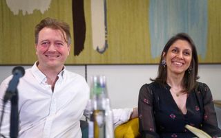 Nazanin Zaghari-Ratcliffe with her husband Richard Ratcliffe sat in front of microphones at a press conference in March 2022.