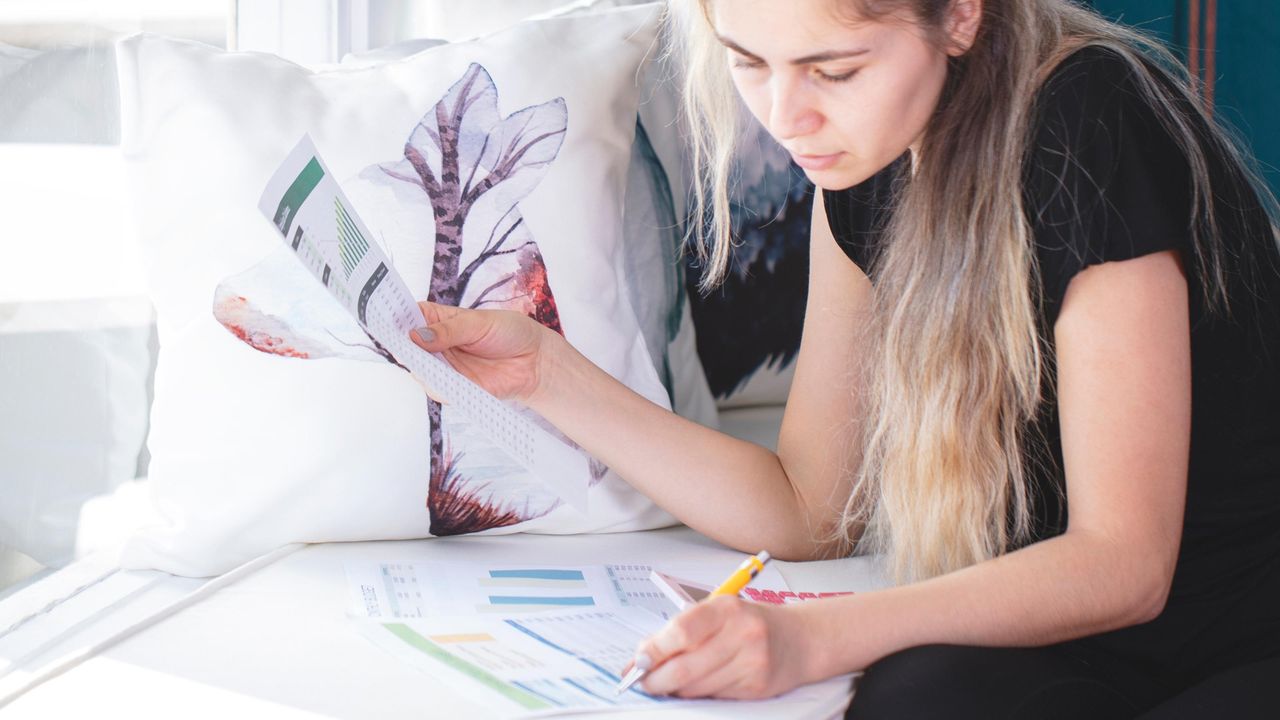 A woman wearing all black sorts through some financial documents.