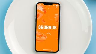Grubhub app on phone with phone on plate