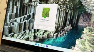 A laptop screen displaying a Windows 11 desktop with a Blip file transfer pop-up window confirming a photo was received from an iPhone.
