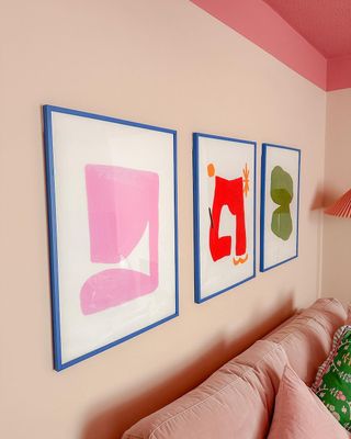 Pink living room wall with framed artwork