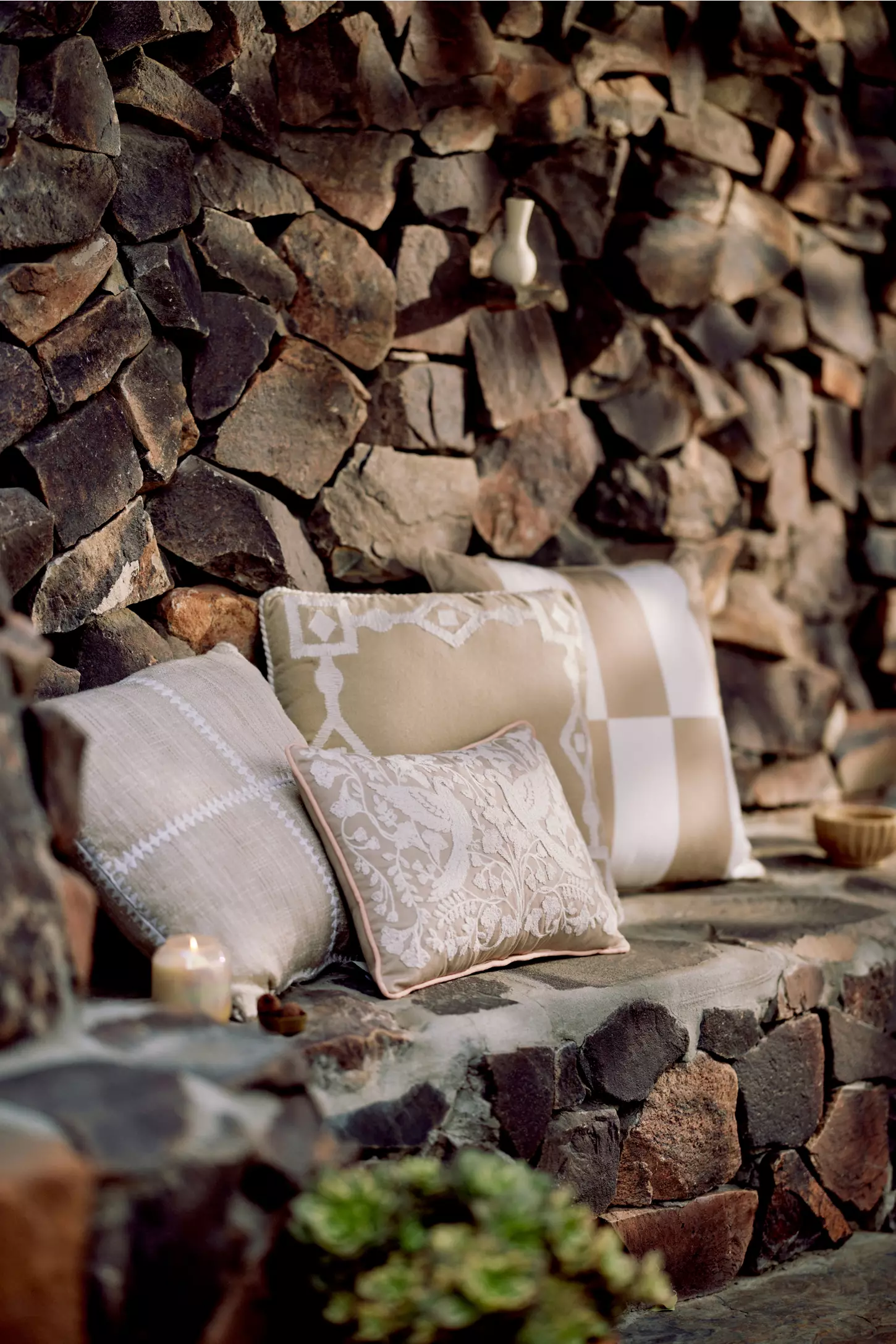 four beige patterned outdoor cushions on a stone bench seat