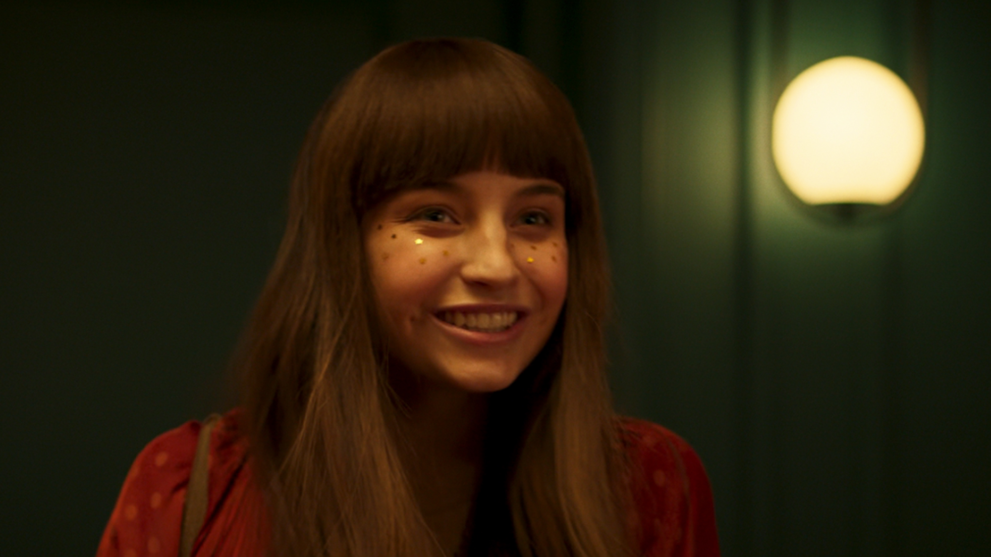 A woman smiling with glitter on her face