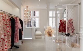 White-washed shop interior displaying a range of red and white outfits
