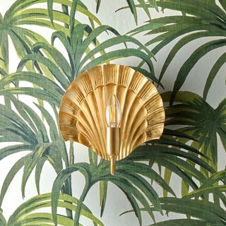 A shell gold light on a wallpaper of palm trees