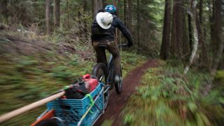 Trail builder riding with his tools