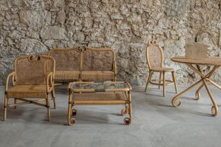 tables and chairs by Alekos Fassianos in front of bare stone walls