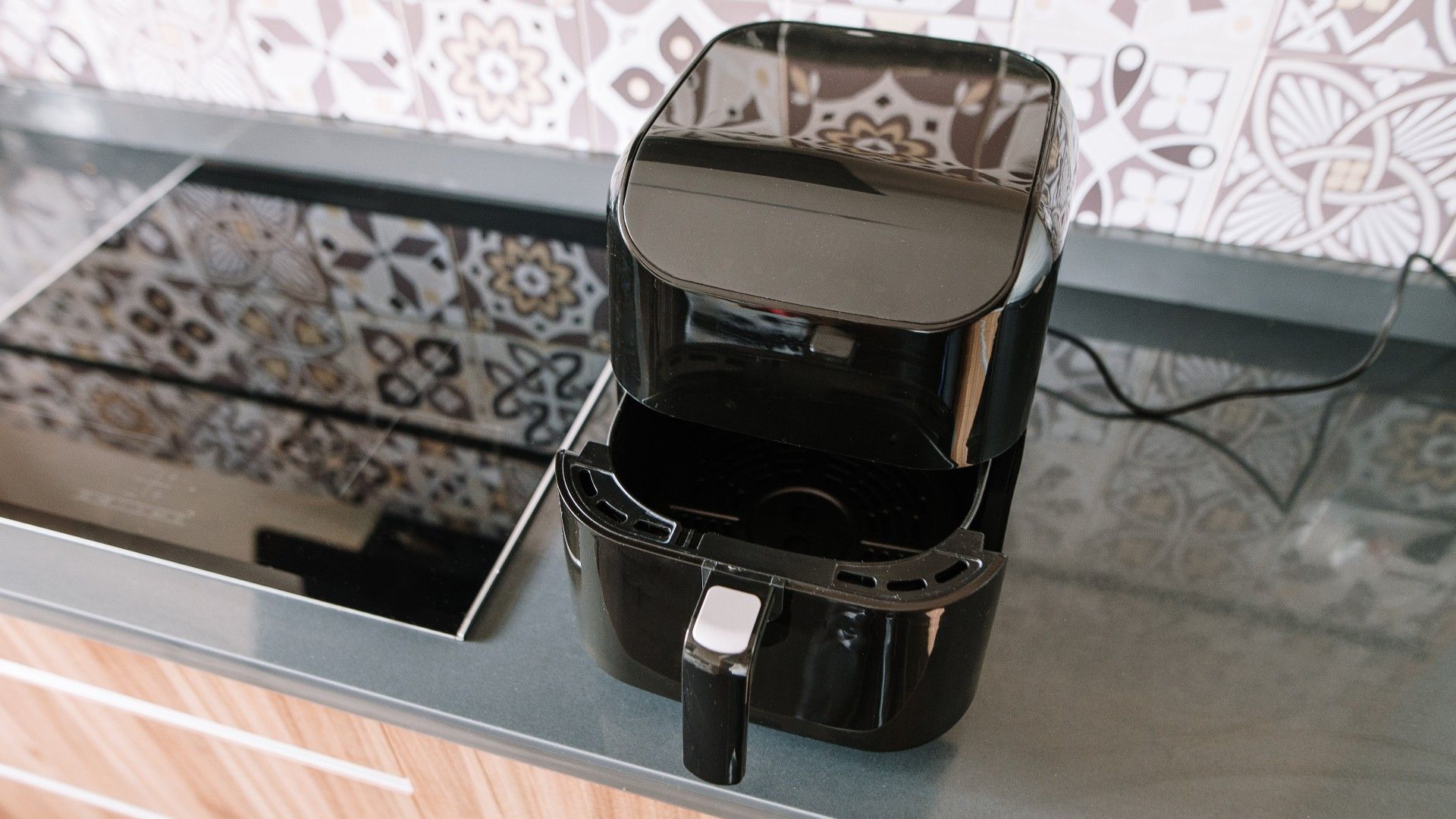 air fryer on a kitchen worktop next to a hob