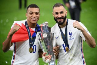 France's forward Kylian Mbappe (L) and France's forward Karim Benzema (R) celebrate with the trophy at the end of the Nations League final football match between Spain and France at San Siro stadium in Milan, on October 10, 2021