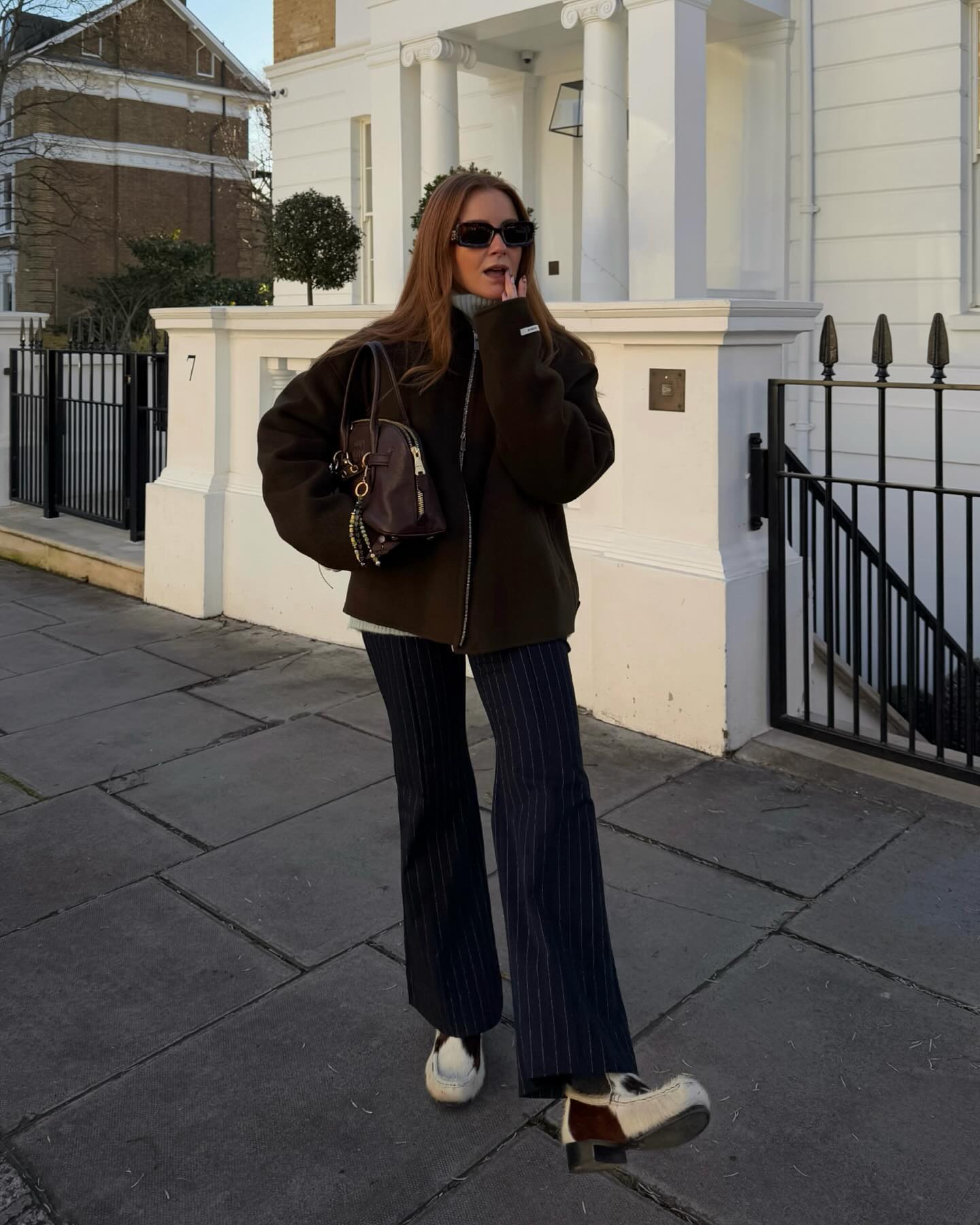 @rebeccaferrazwyatt wears cow print heeled loafers with dark trousers