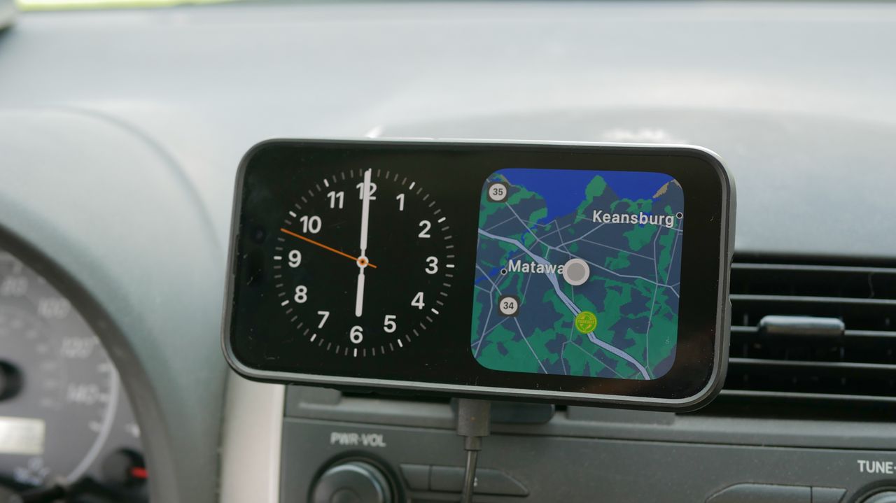 ESR HaloLock MagSafe Car Charger attached to vent clip in car with iPhone.